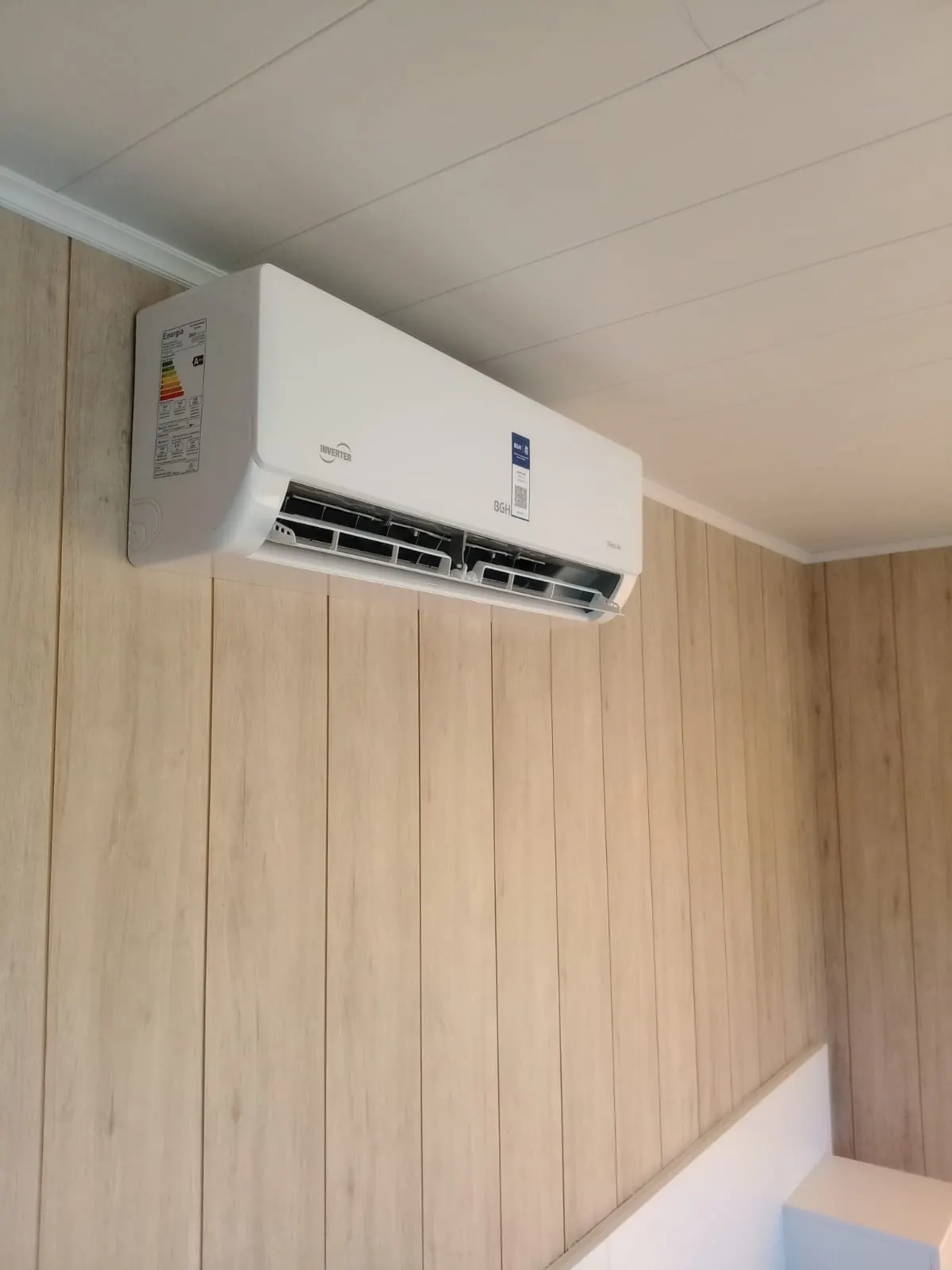 Split BGH inverter instalado en un ambiente con paneles de madera
